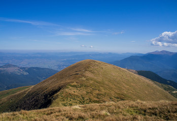 Fototapeta premium Colorful mountain landscape in the summer mountains. Large hills with blue sky.