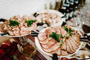 The holiday table with appetizer, meat snacks. Served table with food. Festive table. Wedding table, food. Table at restaurant before starting to celebrate. New Year, Christmas, Easter.