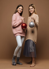 Cute happy girls with a baubles on brown background
