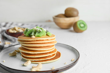 Plate with stack of tasty pancakes on table