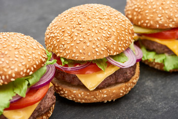 close up view of delicious fresh cheeseburgers on wooden table
