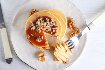 Plate with stack of tasty pancakes on table