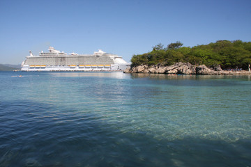 super fine beach on the island in Haiti where some baths and cruise boats in the background.