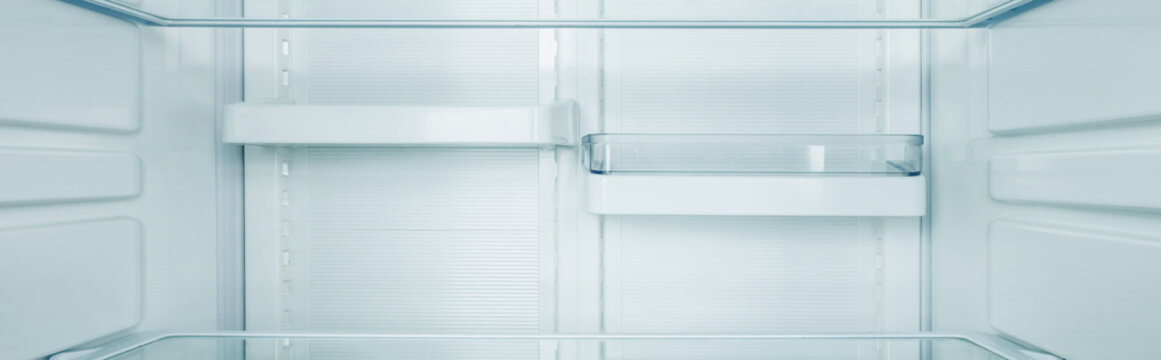 Panoramic shot of clean shelves of refrigerator