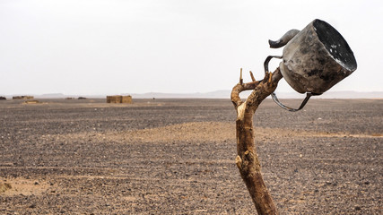 vieja tetera colgada de un palo en el desierto