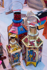 Handmade illuminated decorative hanging lanterns isolated on blurred background are displayed in a street shop for sale. Indian handicraft and art
