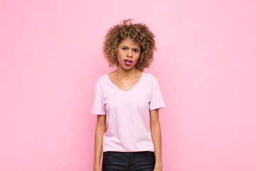 young african american woman feeling puzzled and confused, with a dumb, stunned expression looking...