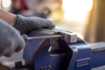 A man using the steel rasp to decorate the work , the hammer to sharpen