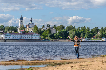 Woman by a river on the background of the Russian town of Myshkin