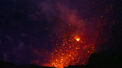 CLOSE UP: Glowing particles of lava fall back to the ground after eruption.