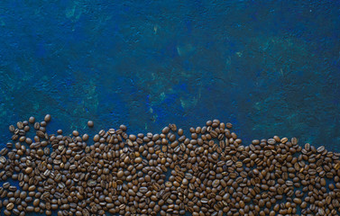 Naklejka na ściany i meble Brown roasted coffee beans, seed on blue background. Espresso dark, aroma, black caffeine drink. Closeup isolated energy mocha, cappuccino ingredient.