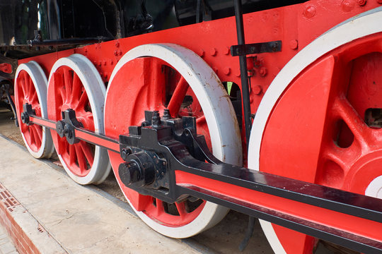 Wheels of an old red steam locomotive