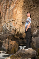 Young man posing in the field and with a bridge in the background. Enjoying the outdoors