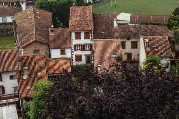 View of the red roofs from the tiles of the French village Saint-Jean-pied-de-Port in the foothills of the Pyrenees. View of the rooftops of a European mountain village in France. Camino de Santiago.