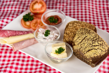 on a red chequered tablecloth is a plate with a hearty breakfast and a cup of black coffee