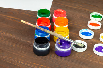 retro style wooden background. It has paint in cans and a brush for painting. Close-up. Tinted
