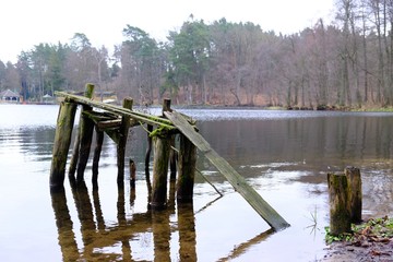 Wooden destroyed jetty at a lake in an autumn day. Lapinskie Lake, Lapino, Kashubia, Poland