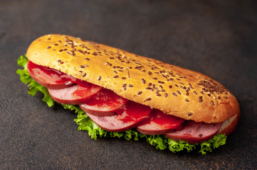 large panini sandwich with sausage and cheese on a stone background with copy space for your text