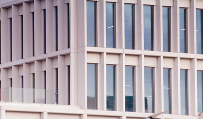 Geometric pattern from part of building facade. Modern architecture of commercial building walls and windows made of glass.