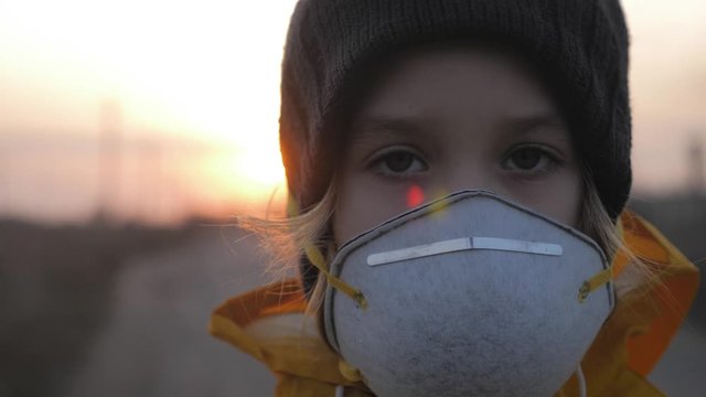 Child girl in protective mask on industrial plant smoke background. Atmospheric pollution and people health concept.
