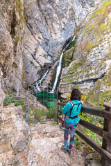 Alpine waterfall Savica in the nation park Triglav, Slovenia. Mother carrying baby in front.