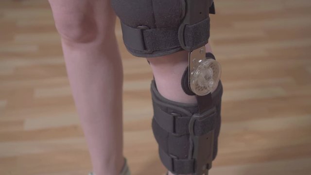 Female leg with orthosis knee brace after injury