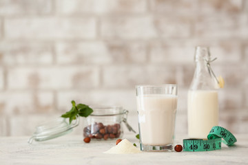 Tasty protein shake with measuring tape on light table