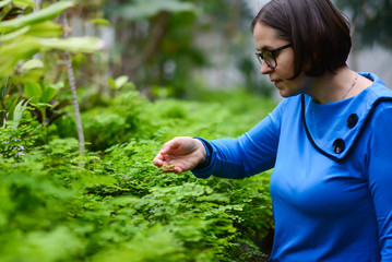 Happy relax Caucasian middle aged woman enjoying with her greenhouse garden. Attractive woman gardening her tree plant in her secret garden. Middle age hobby lifestyle and mental health care concept.