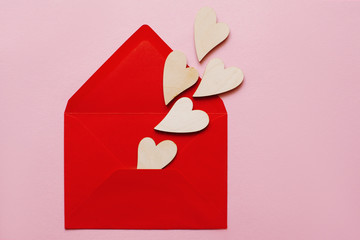 Wooden beautiful hearts in a red paper envelope love message for Valentine's Day and Women's Day