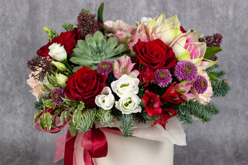 fresh arrangement of bright flowers in a hat box florist work place for text