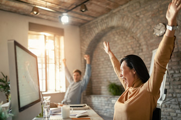 Female Asian entrepreneur screaming while celebrating business success in the office.