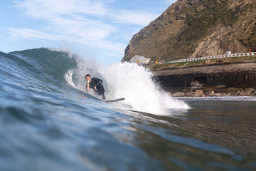 boy surfing while eating an ice cream cone with several balls of different flavors