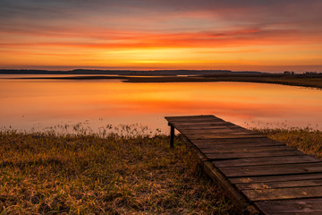 Fototapeta na wymiar Beautiful sunrise over lake banks