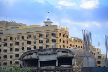 Fototapeta premium Zerstörtes Altes Kino in Beirut vor mehrstöckigem Gebäude und blauem Himmel