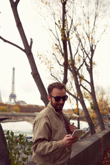 Handsome man using cellphone while enjoying in Paris.