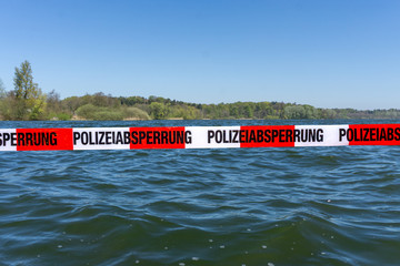 Polizeiabsperrung am einem See