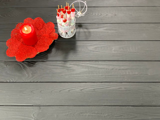 Red candle on a black background, romantic background with a heart. Postcard with place for text, for the holiday.