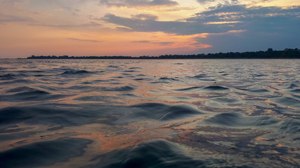 Fototapeta na wymiar Sunset over the sea water surface in Grado, Italy