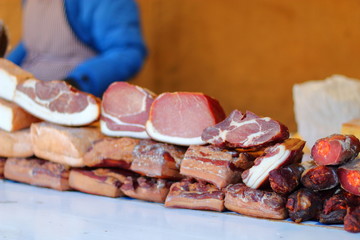 Various slices of smoked meat with streaks of fat.