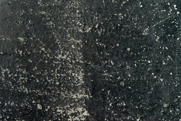 an empty background of black concrete that is worn down or weathered showing texture with copy space or space for tekst