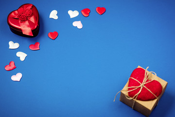 Red heart with a gift to Valentine's Day on a beautiful blue background. Heart pendant. Space for...