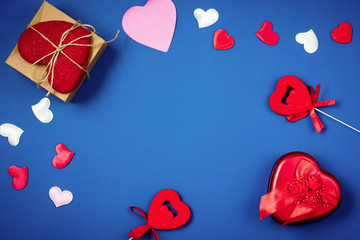 Red heart with a gift to Valentine's Day on a beautiful blue background. Heart pendant. Space for...