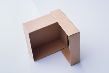 Two box pieces are standing on ribs making angle. Isolated on white, perspective view.