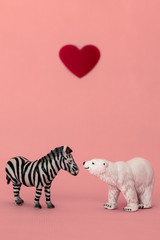 Love between the different and opposed: a bear, carnivorous from a cold habitat and a zebra, herbivorous from a hot habitat. Tolerance and respect to the people that think on a different way as we do.