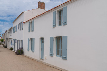 Fototapeta na wymiar white house blue shutter in street in Noirmoutier island