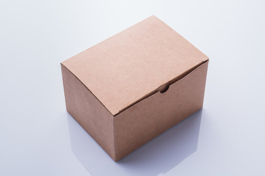 Closed Plain Cardboard Box. Perspective Angle View, Isolated On White Background With Craft.