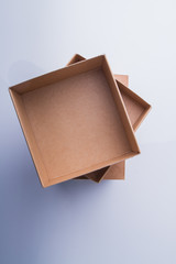 Stack of three cardboard boxes, top view. Column of beige carton conatiners.