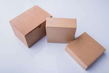 Three different beige cardboard boxes. Isolated on white.