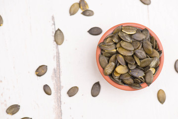Pumkin seeds on a white shabby background, empty copy space
