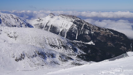 Fototapeta na wymiar Panorama ze szczytu górskiego na zaśnieżone górskie szczyty